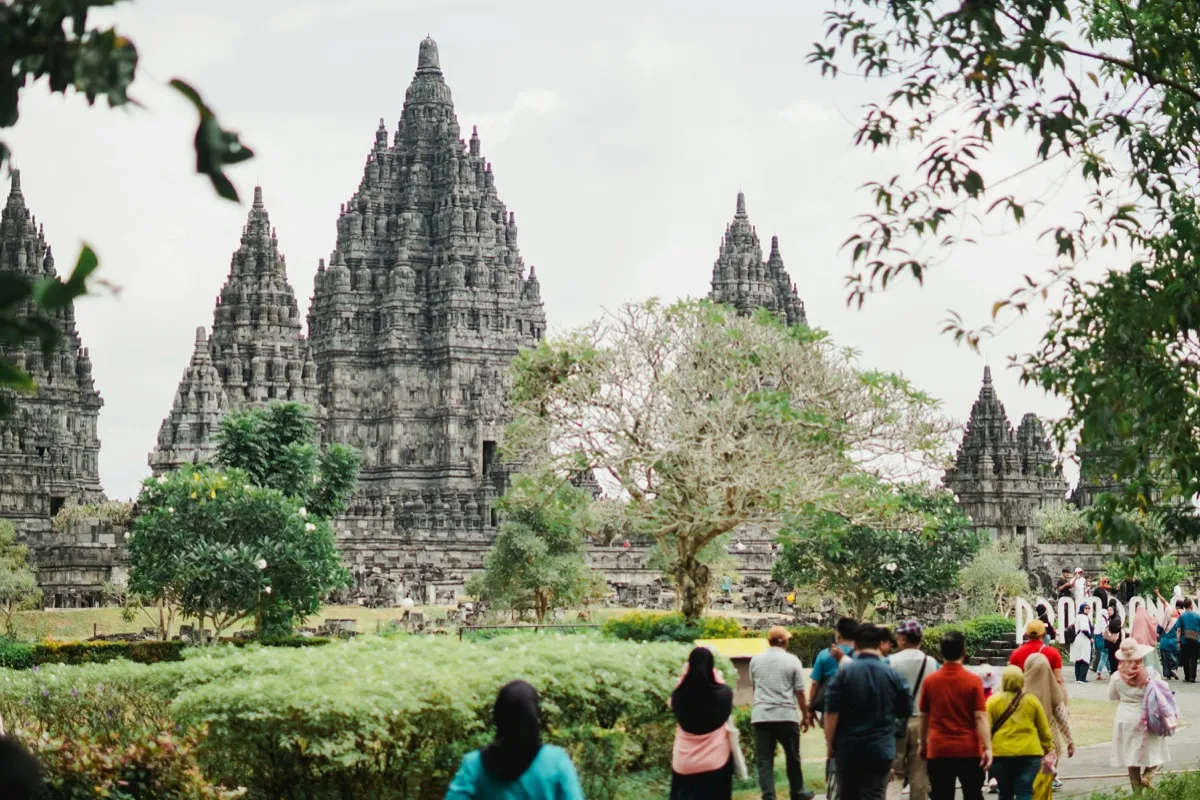 穿着得体热带服饰的游客正穿行于普兰巴南(Prambanan)的中央庭院——这座爪哇岛上仍在使用的印度教宗教场所要求游客穿着长裤或长裙，并备好遮阳帽与包脚鞋。